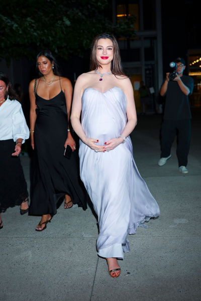 Anne Hathaway wears a silverblue gown and red lipstick and nails.
